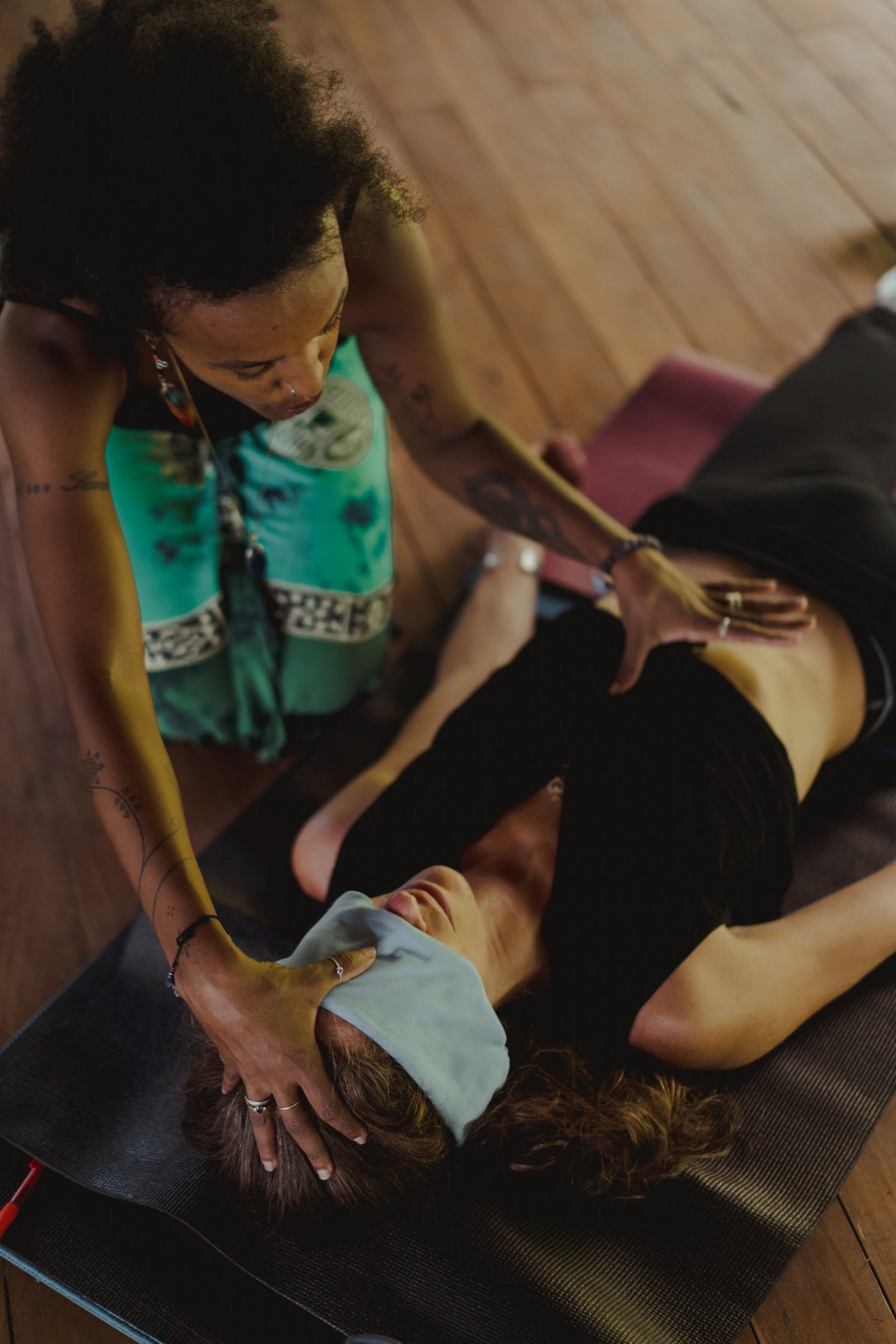 Badria holding a blindfolded client's head during a Kundalini Activation session